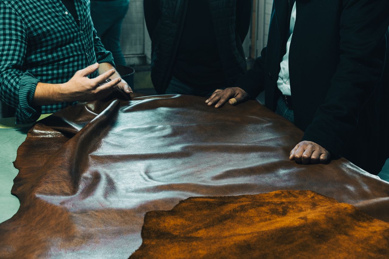 A group of craftsmen examining leather on a table in Gerede, Bolu, Türkiye.